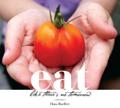 Fresh tomato in hands promoting the philosophy to Eat Like There's No Tomorrow by Hans Rueffert.